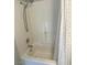 Clean white tiled bathroom with shower and tub combination and neutral-patterned shower curtain at 8328 Cimarron Ridge Dr, Las Vegas, NV 89128