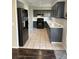 The kitchen features dark cabinets, light countertops, tile flooring, and stainless steel appliances at 8328 Cimarron Ridge Dr, Las Vegas, NV 89128
