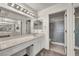 Bright bathroom featuring white cabinets, marble countertop, and a shower with sliding glass doors at 8904 Evening Star Dr, Las Vegas, NV 89134