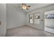 Bright bedroom with neutral tile flooring, a ceiling fan, and a sliding glass door leading to outdoor space at 8904 Evening Star Dr, Las Vegas, NV 89134