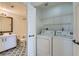 A convenient laundry room with washer, dryer and storage shelving, adjacent to a bathroom at 900 Heavenly Hills Ct # 112, Las Vegas, NV 89145