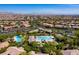 Wide aerial view showcasing pools, desert landscaping, clubhouse amenities within a community of single-Gathering homes at 9077 Creed Mountain Pl, Las Vegas, NV 89178
