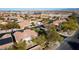 A high, wide aerial view of a vibrant neighborhood with tree-lined streets and charming homes nestled in a desert landscape at 9077 Creed Mountain Pl, Las Vegas, NV 89178