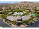 Aerial view showcasing pools, desert landscaping, and clubhouse amenities within a community of single-Gathering homes at 9077 Creed Mountain Pl, Las Vegas, NV 89178