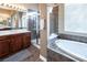 Bathroom featuring walk-in shower, soaking tub, dual vanities, and tile flooring at 9077 Creed Mountain Pl, Las Vegas, NV 89178