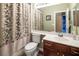 Bathroom with a shower-tub combo, vanity with storage, and large mirror at 9077 Creed Mountain Pl, Las Vegas, NV 89178