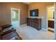 Cozy bedroom featuring a TV, dresser, and comfortable seating, creating a relaxing retreat at 9077 Creed Mountain Pl, Las Vegas, NV 89178