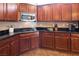 Kitchen with dark wood cabinetry, stainless steel microwave, gas stovetop, and granite countertops at 9077 Creed Mountain Pl, Las Vegas, NV 89178
