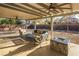 Relaxing covered patio featuring comfortable seating, ceiling fans, and a cozy fire pit for outdoor gatherings at 9077 Creed Mountain Pl, Las Vegas, NV 89178