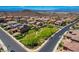 An aerial view of a neighborhood with houses featuring solar panels and a central community park at 917 Pomander Point Pl, Henderson, NV 89012