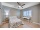 Cozy bedroom with floral bedding, sleek ceiling fan, modern desk, and a window for natural light at 917 Pomander Point Pl, Henderson, NV 89012