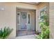 Home entrance showcases security gate, wreath, and planter with blossoming red roses at 917 Pomander Point Pl, Henderson, NV 89012