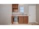 Stylish mini-bar area with wooden cabinets, granite countertop, stainless steel beverage cooler, and natural lighting at 917 Pomander Point Pl, Henderson, NV 89012