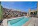 Backyard pool with stone retaining wall, offering a serene and private outdoor experience at 917 Pomander Point Pl, Henderson, NV 89012