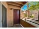 Exterior balcony view showcasing a secure brown front door, siding, and beautiful desert foliage at 9325 W Desert Inn Rd # 143, Las Vegas, NV 89117