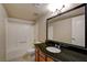 Bathroom with a shower-tub combo, granite counters, and a decorative mirror at 9325 W Desert Inn Rd # 143, Las Vegas, NV 89117