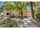 Well-maintained condo exterior featuring desert landscaping, mature trees, and a paved walkway at 9325 W Desert Inn Rd # 143, Las Vegas, NV 89117
