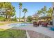 Inviting backyard featuring a sparkling pool, patio with shaded pergola, and lush landscaping at 9921 Heffner Hills Cir, Las Vegas, NV 89117