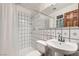 Simple white bathroom features white tile walls, a shower with a curtain, and a pedestal sink with chrome fixtures at 9921 Heffner Hills Cir, Las Vegas, NV 89117