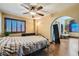 Bedroom featuring hardwood floors, a ceiling fan, shutters, and views through an archway into another room at 9921 Heffner Hills Cir, Las Vegas, NV 89117