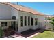 Rear exterior view showcasing a tile roof, several windows, a small patio area, and garden access at 9921 Heffner Hills Cir, Las Vegas, NV 89117
