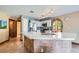 Bright kitchen showcases an island with a quartz countertop, white cabinets, stainless steel appliances, and a stone archway at 9921 Heffner Hills Cir, Las Vegas, NV 89117