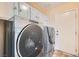 Laundry room with front loading washer and dryer and upper cabinets for storage at 9921 Heffner Hills Cir, Las Vegas, NV 89117