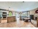 Open concept living space featuring a kitchen, dining area, and cozy living room with a stone fireplace at 9921 Heffner Hills Cir, Las Vegas, NV 89117