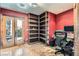 Cozy home office with custom built-in shelving, functional desk setup, and natural light from French doors at 9921 Heffner Hills Cir, Las Vegas, NV 89117