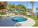 Backyard pool surrounded by mature trees and grass at 9921 Heffner Hills Cir, Las Vegas, NV 89117