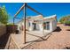 Relaxing backyard with a stone patio, wooden pergola, and low-maintenance landscaping at 10404 Shadowland Ave, Las Vegas, NV 89144