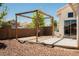 Spacious backyard featuring a wooden pergola, patio area, and desert landscaping at 10404 Shadowland Ave, Las Vegas, NV 89144