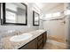 Bathroom featuring dual sinks, granite countertops, and a modern glass shower with custom tile at 10404 Shadowland Ave, Las Vegas, NV 89144