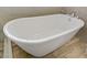 Freestanding bathtub features chrome faucet and light tile surround at 11249 Revelry Ln, Las Vegas, NV 89138