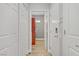 Hallway featuring bright white doors, wood flooring and a view of the laundry room at 11249 Revelry Ln, Las Vegas, NV 89138