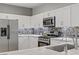 Modern kitchen with stainless steel appliances, marble countertops, and white cabinetry at 11249 Revelry Ln, Las Vegas, NV 89138