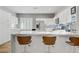 Bright kitchen features a marble countertop island with seating, stainless steel appliances, and sleek white cabinetry at 11249 Revelry Ln, Las Vegas, NV 89138