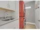 Modern laundry room showcasing stacked washer and dryer and sink with white countertops at 11249 Revelry Ln, Las Vegas, NV 89138