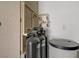 Close up of the water filtration system in the utility room next to storage cabinet at 11249 Revelry Ln, Las Vegas, NV 89138