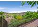 Backyard view of lush landscaping, golf course, mountains, and clear blue sky seen from upper deck at 12 Via Ravello, Henderson, NV 89011