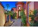 Charming home entrance featuring a stone pathway, lush landscaping, and a decorative front door at 12 Via Ravello, Henderson, NV 89011