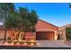 Beautiful home exterior featuring a well-maintained lawn, mature tree, and a two-car garage at 12 Via Ravello, Henderson, NV 89011