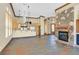 Open-concept living room with stone fireplace, built-in shelving, and access to kitchen and front entry at 12 Via Ravello, Henderson, NV 89011