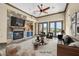 Staged living room features a stone fireplace, comfortable seating, and a stylish coffee table at 12 Via Ravello, Henderson, NV 89011