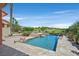 Backyard pool and patio with waterfalls and lush landscaping, set against a golf course and clear blue sky at 12 Via Ravello, Henderson, NV 89011