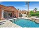 Relaxing pool and patio area with stone accents, a built-in grill, and a beautiful, desert landscape at 12 Via Ravello, Henderson, NV 89011