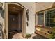 Inviting front entrance with a modern door, stylish light fixture, and charming bench and potted plants at 12024 Girasole Ave, Las Vegas, NV 89138