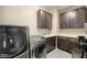Laundry room with a front load washer and dryer and ample storage space at 12024 Girasole Ave, Las Vegas, NV 89138