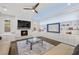 Bright living room with a fireplace, ceiling fan, and built-in shelving at 12024 Girasole Ave, Las Vegas, NV 89138