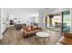 Open floor plan featuring hardwood floors, a leather sofa, and a sliding glass door to the backyard at 12024 Girasole Ave, Las Vegas, NV 89138